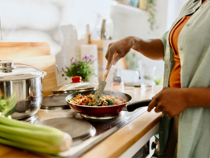 woman cooking food in a saucepan