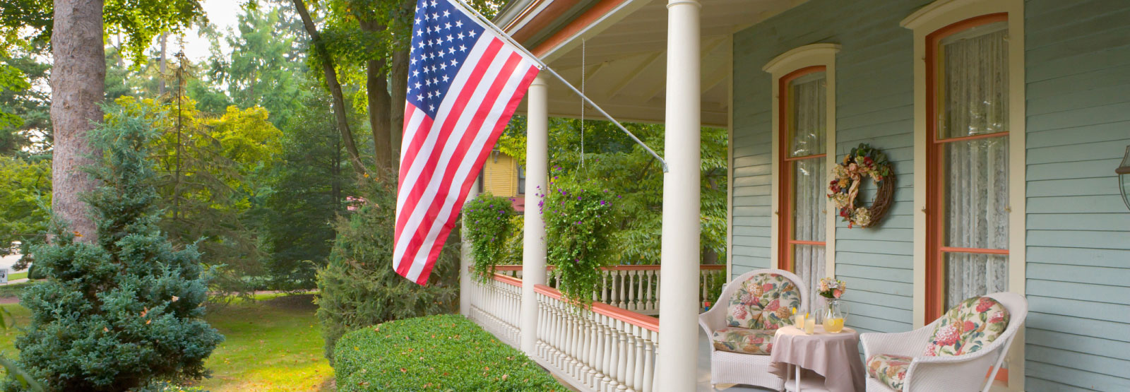 an american flag hanging on the front of a blue house