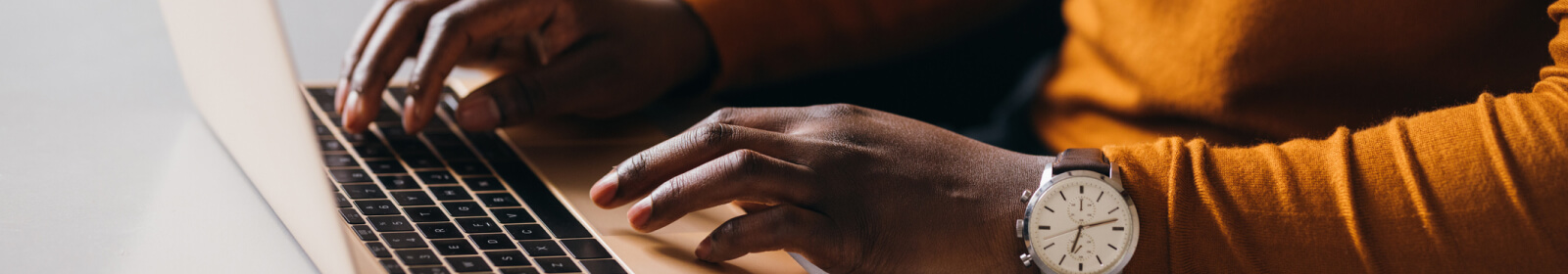 close-up of hands on a laptop keyboard